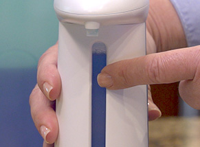 Image of a woman in a robe using Sonic Soap to get soap out